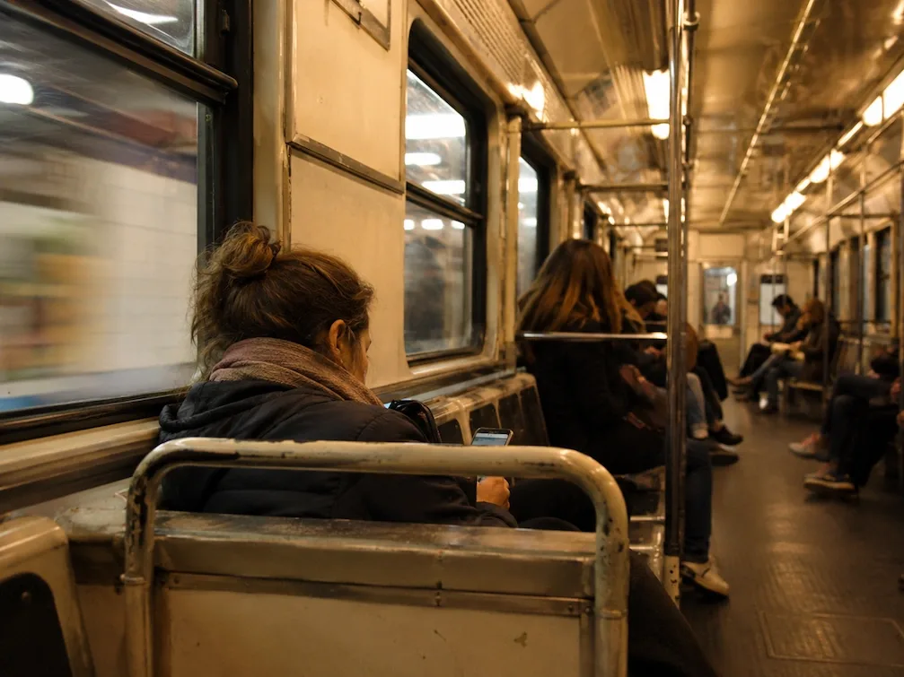 The wood-panelled interior of a vintage Buenos Aires Subte carriage with seated passengers