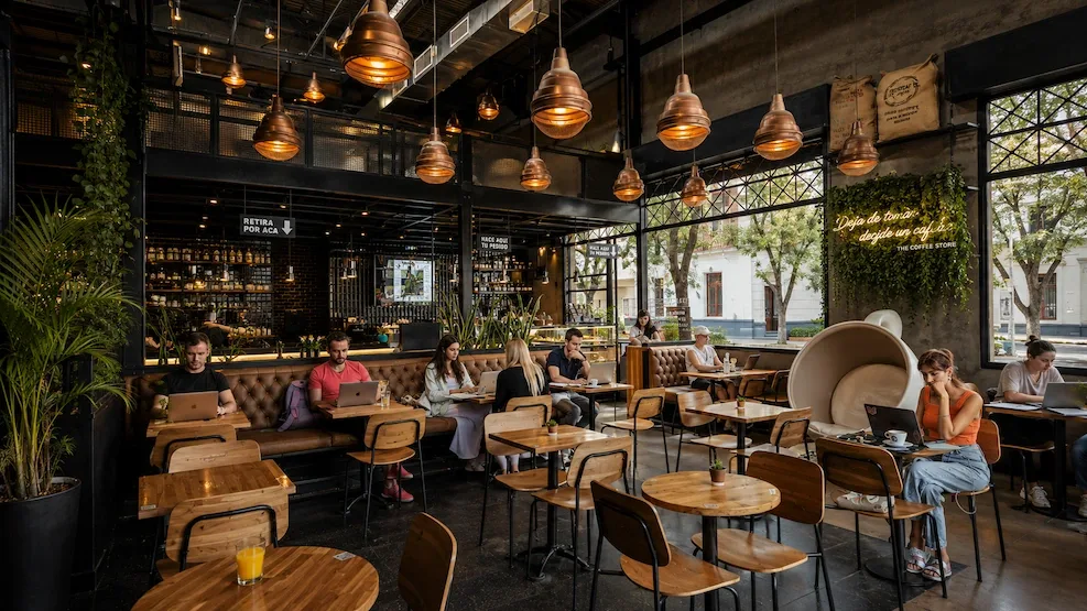 Laptops open across a big industrial cafe in Buenos Aires