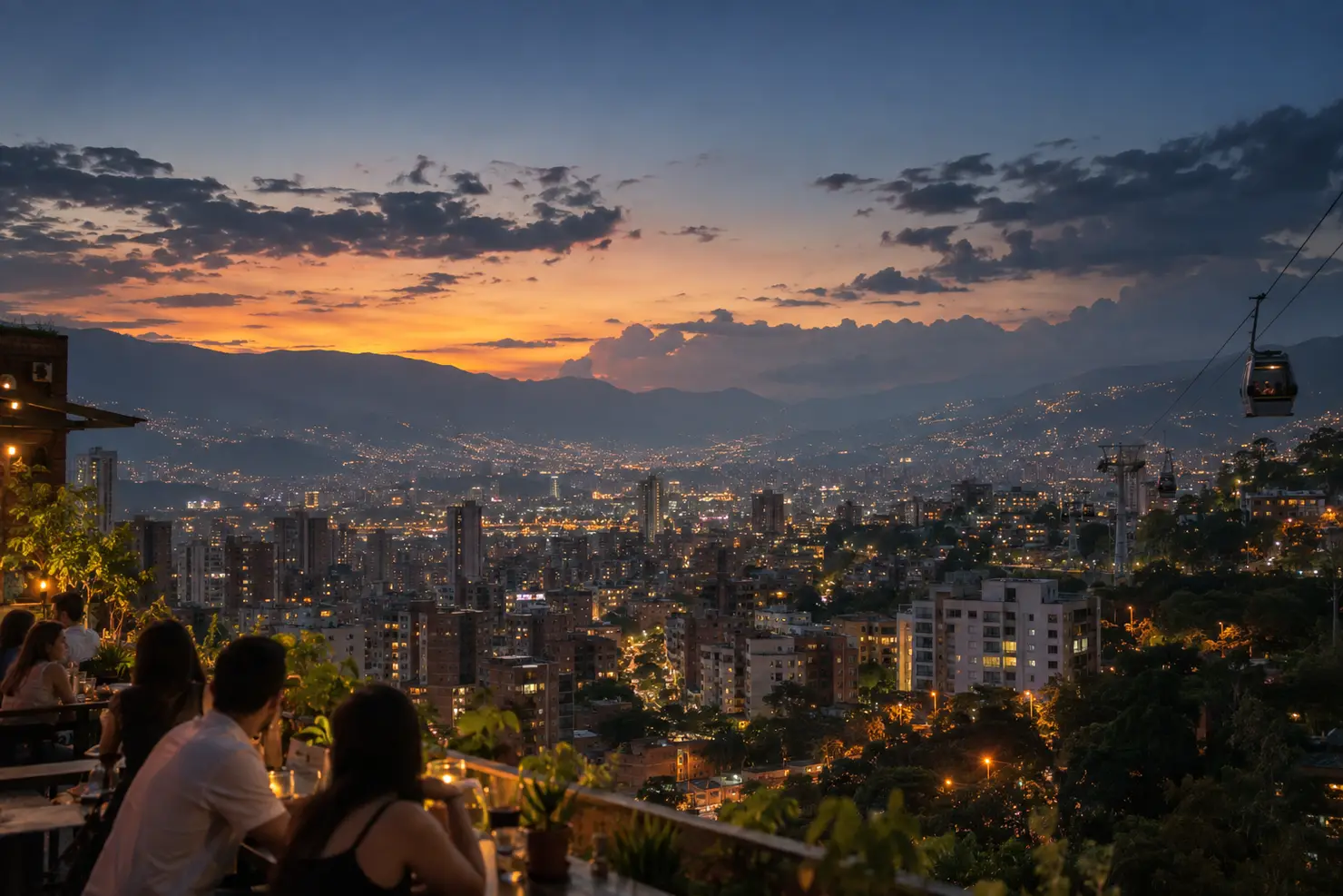 The Aburrá valley at dusk from a Laureles rooftop, Medellín's lights coming on below the ridge