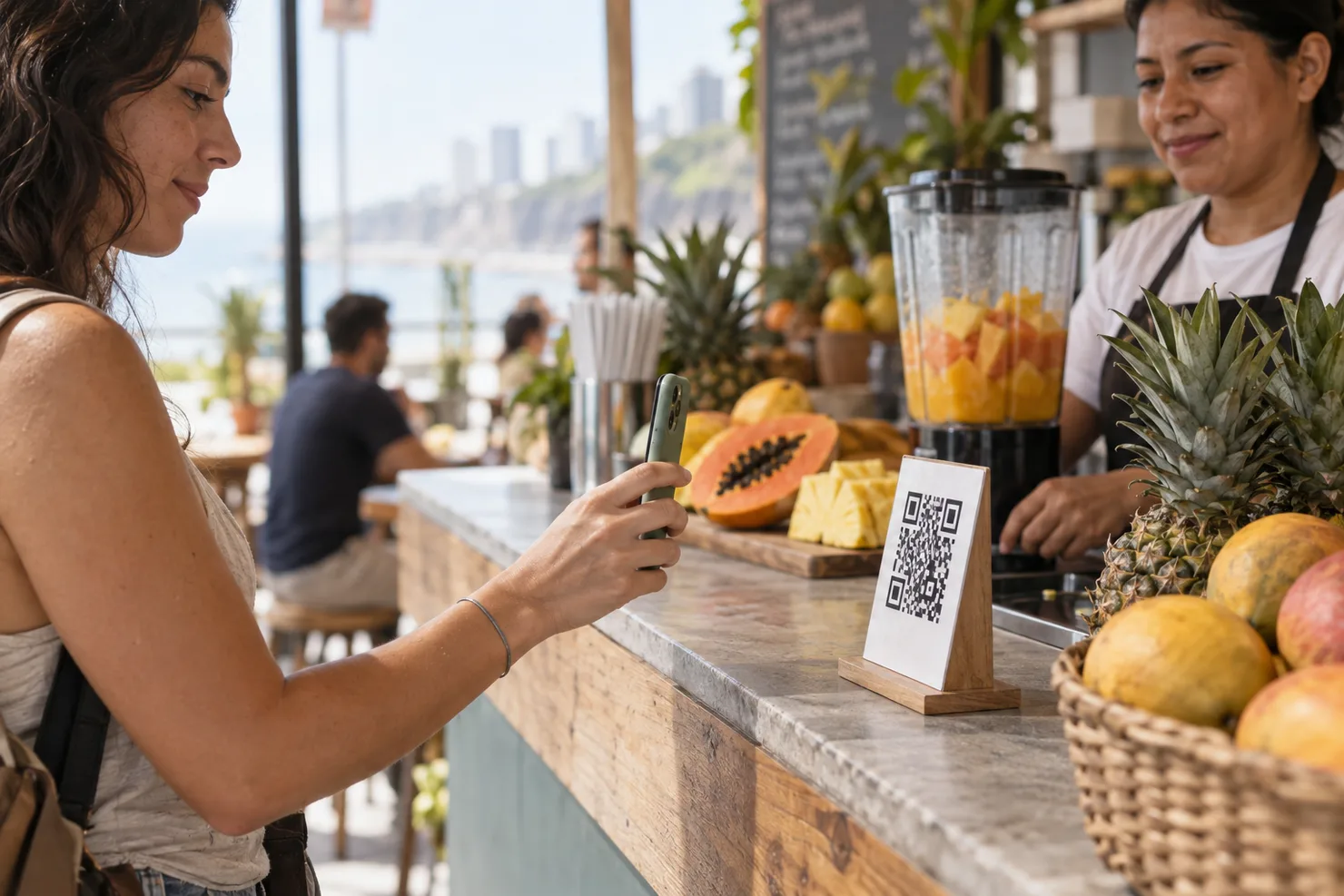 A customer raising a phone to a QR standee on a Miraflores juice-bar counter, the screen turned away