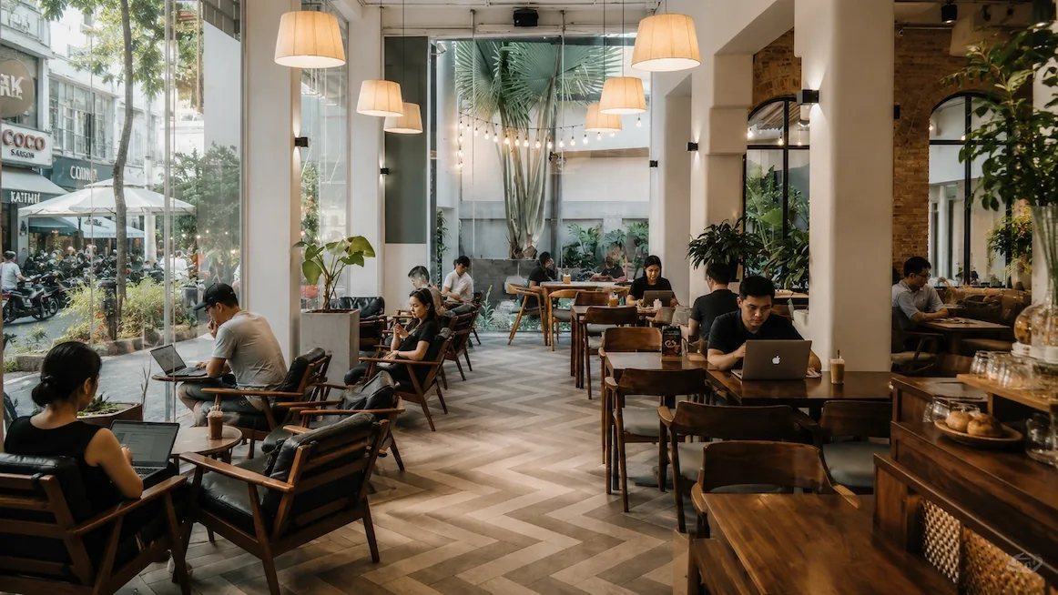 Laptops open across a bright Saigon cafe