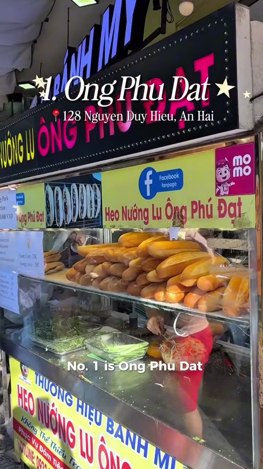 A creator poses with a banh mi outside a Da Nang street-food stall, midway through a tour of five local restaurants.
